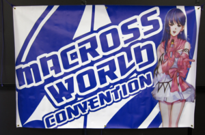 Macross World Convention Sign with an anime girl holding a mic and singing