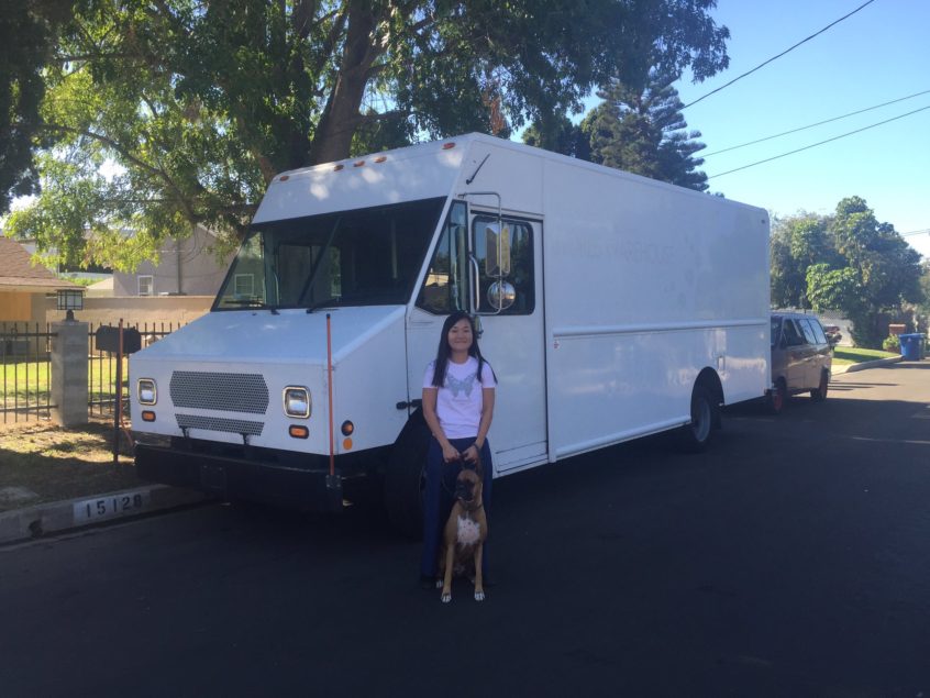 A mysterious white, new truck with our chef Chizuru and Honey standing in front of it.